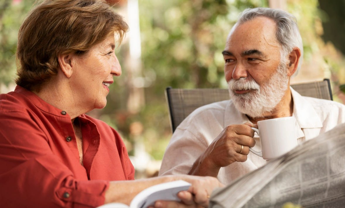 Mature couple reading and talking together outdoors