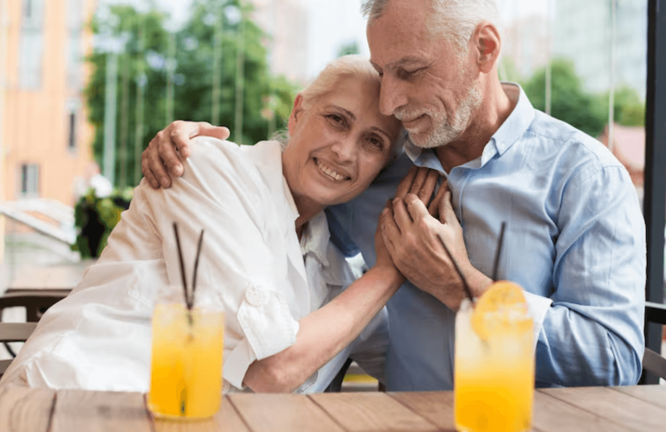 Mature couple laughing together at an outdoor table