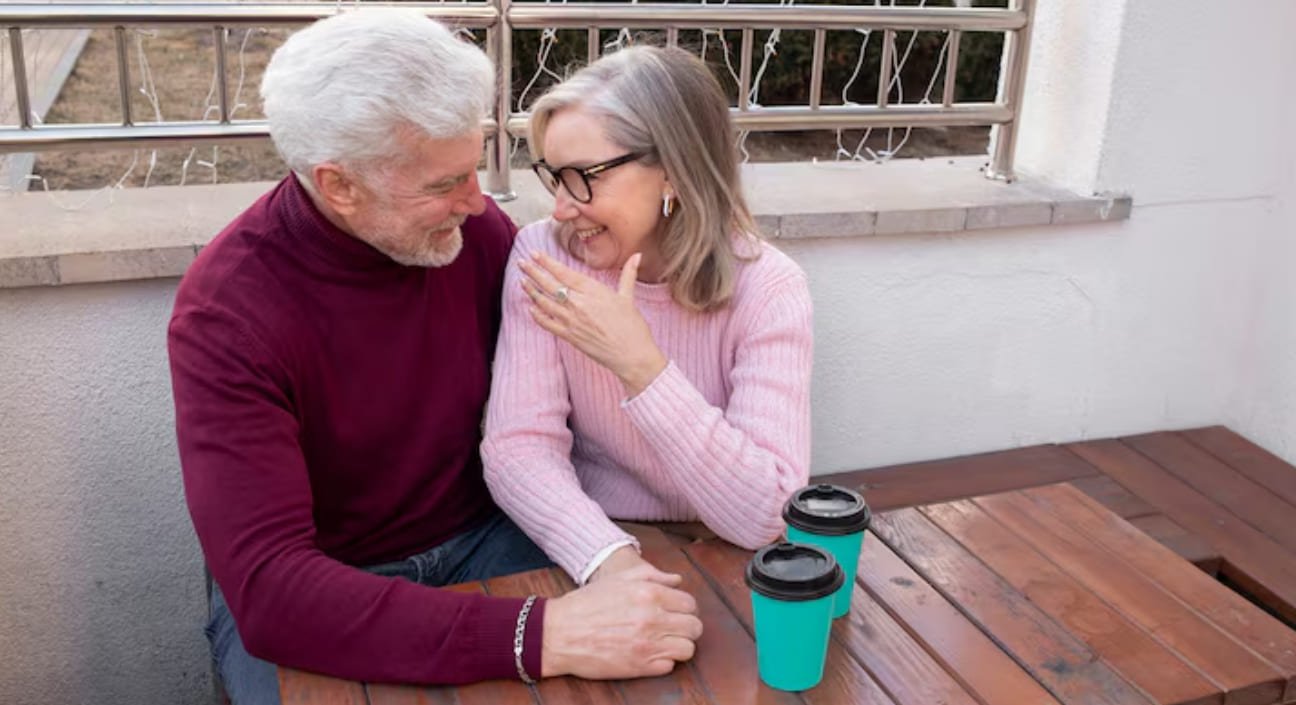 Mature couple laughing over coffee at an outdoor table