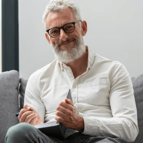 Mature man reviewing notes thoughtfully at home
