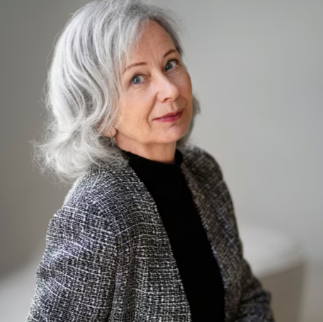 Mature woman sitting thoughtfully indoors